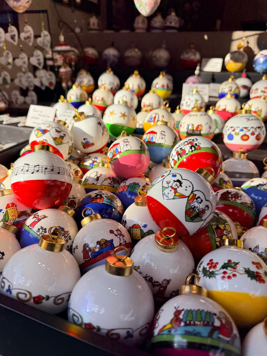 Boules de Noël naïves peintes à la main, aux dessous rouges, bleus, roses et jaunes.