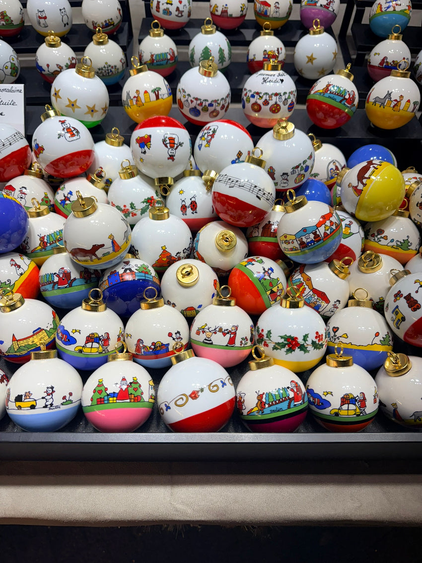 Assortiment de boules de Noël naïves avec leurs dessins originaux et leurs dessous colorés.